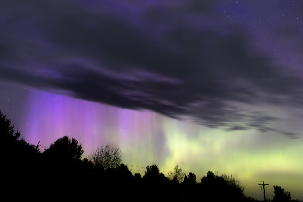 Green curtains of the aurora borealis above Lake Superior, photographed by Forbes Robertson from his rooftop in Houghton, Michigan on the night of May 16, 2026.